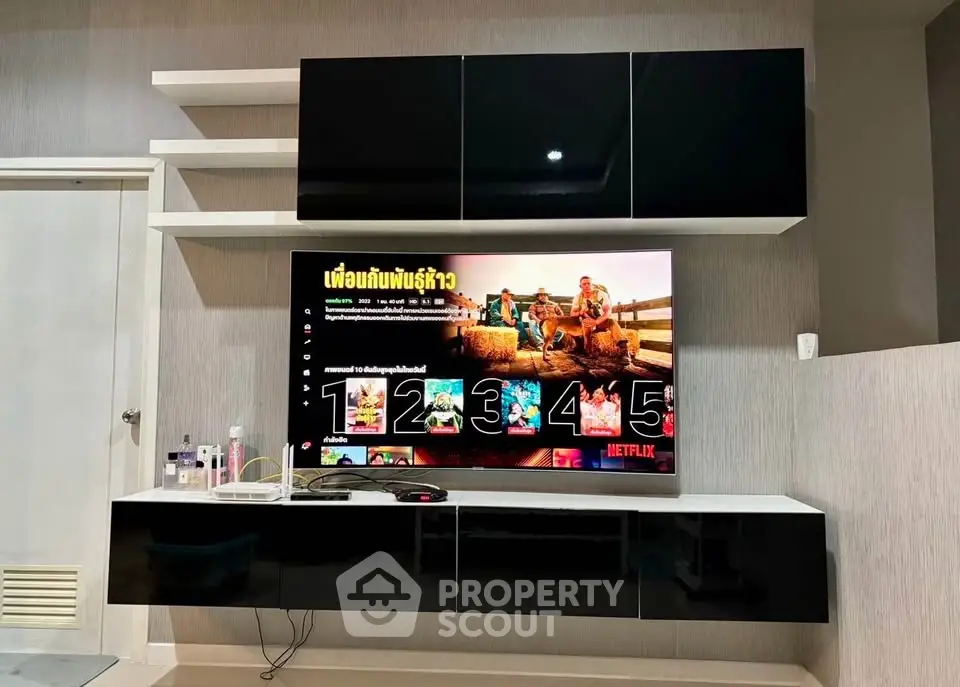 Modern living room with sleek black entertainment unit and wall-mounted TV displaying Netflix.