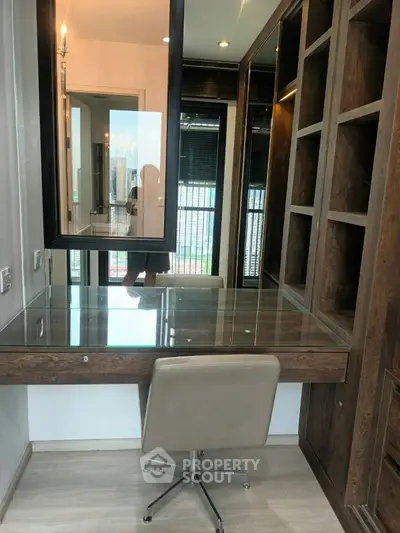 Modern study area with glass desk and built-in wooden shelves in a high-rise apartment.