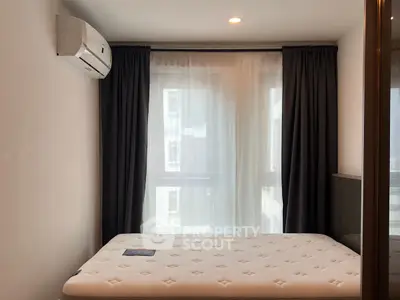 Cozy bedroom with natural light and modern air conditioning unit.