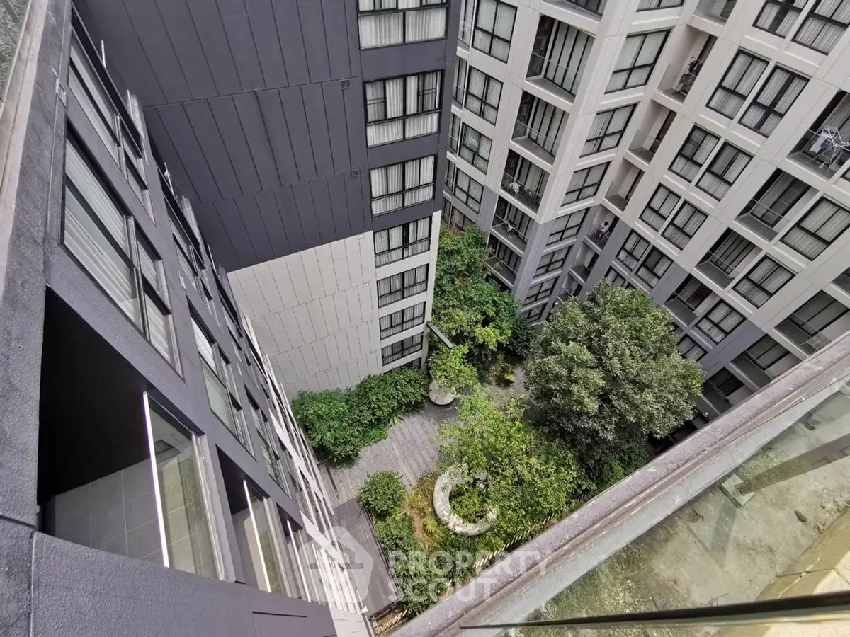 Stunning view of modern apartment building with lush courtyard garden