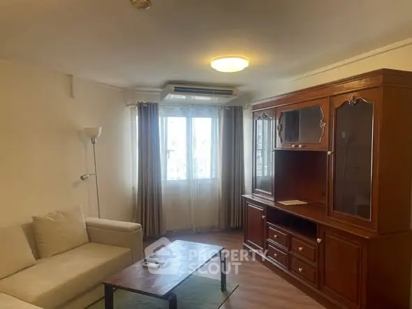 Cozy living room with elegant wooden cabinet and comfortable seating, perfect for relaxation.