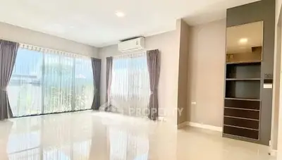 Spacious living room with large windows and modern air conditioning unit.