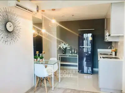Modern kitchen with sleek design, featuring dining area and stainless steel appliances in a stylish apartment.