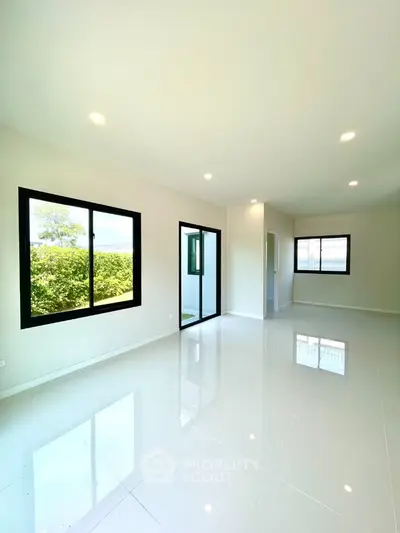 Spacious modern living room with large windows and glossy tile flooring