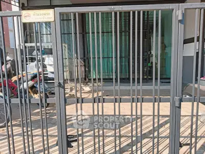 Secure gated entrance to modern property with motorbike parking area.