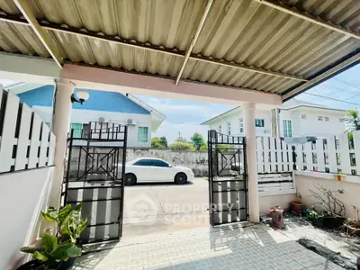 Charming residential entrance with covered parking and gated access in a serene neighborhood.