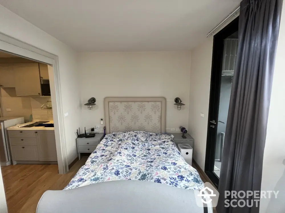 Cozy bedroom with floral bedding and modern decor adjacent to a stylish kitchen.