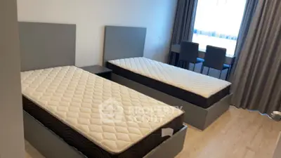 Modern bedroom with twin beds and natural light from large window