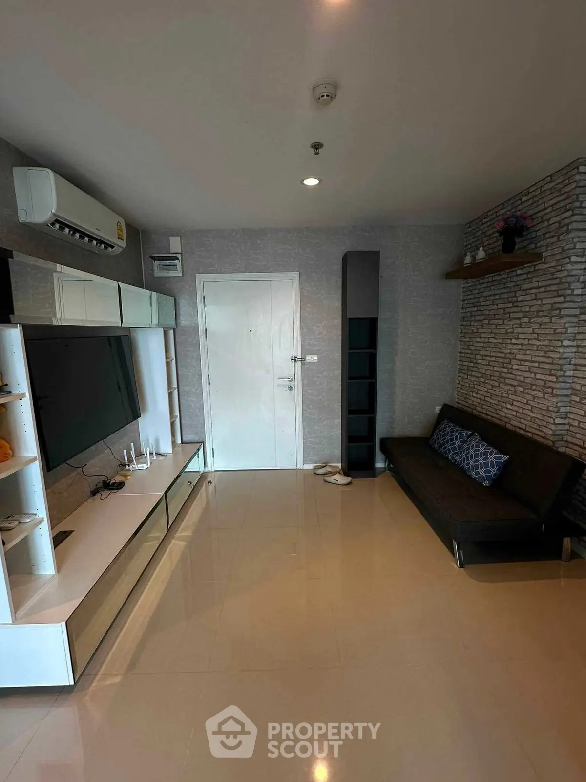 Modern living room with sleek furniture and wall-mounted TV in a stylish apartment.