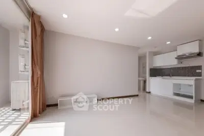 Spacious modern living room with open kitchen and natural light