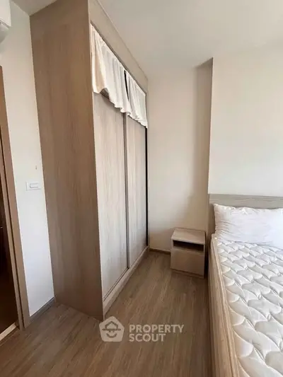 Modern bedroom with wooden wardrobe and comfortable bed in a stylish apartment.