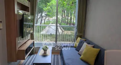 Cozy living room with garden view, featuring modern decor and large window for natural light.