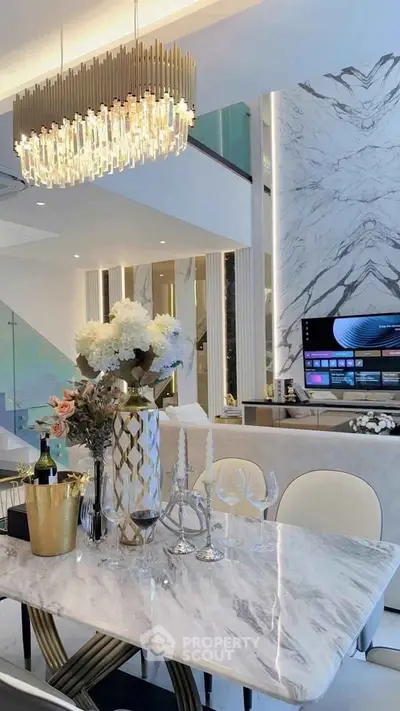 Luxurious modern living room with elegant chandelier and marble accents