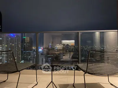 Stunning cityscape view from a modern balcony at night with sleek furniture.