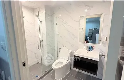 Modern bathroom with glass shower and sleek fixtures in a contemporary apartment.