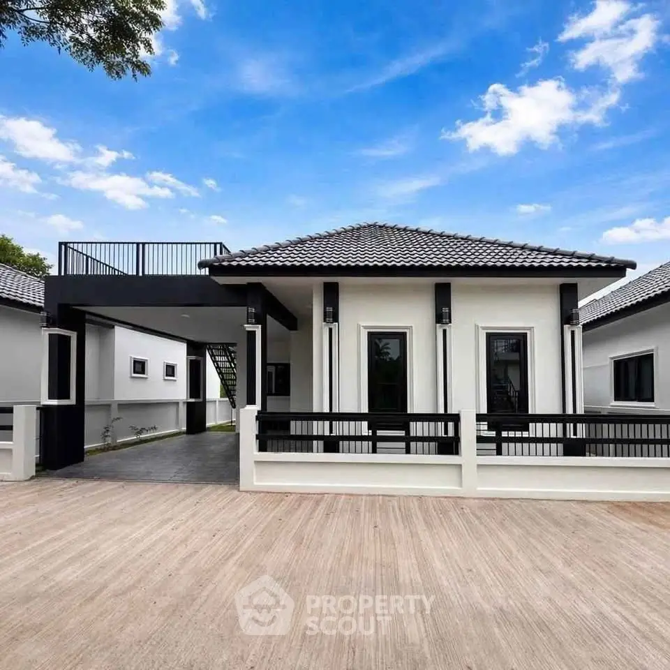 Modern single-story house with sleek design and spacious driveway under a clear blue sky.