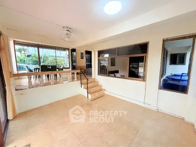 Spacious living room with elevated dining area and large windows