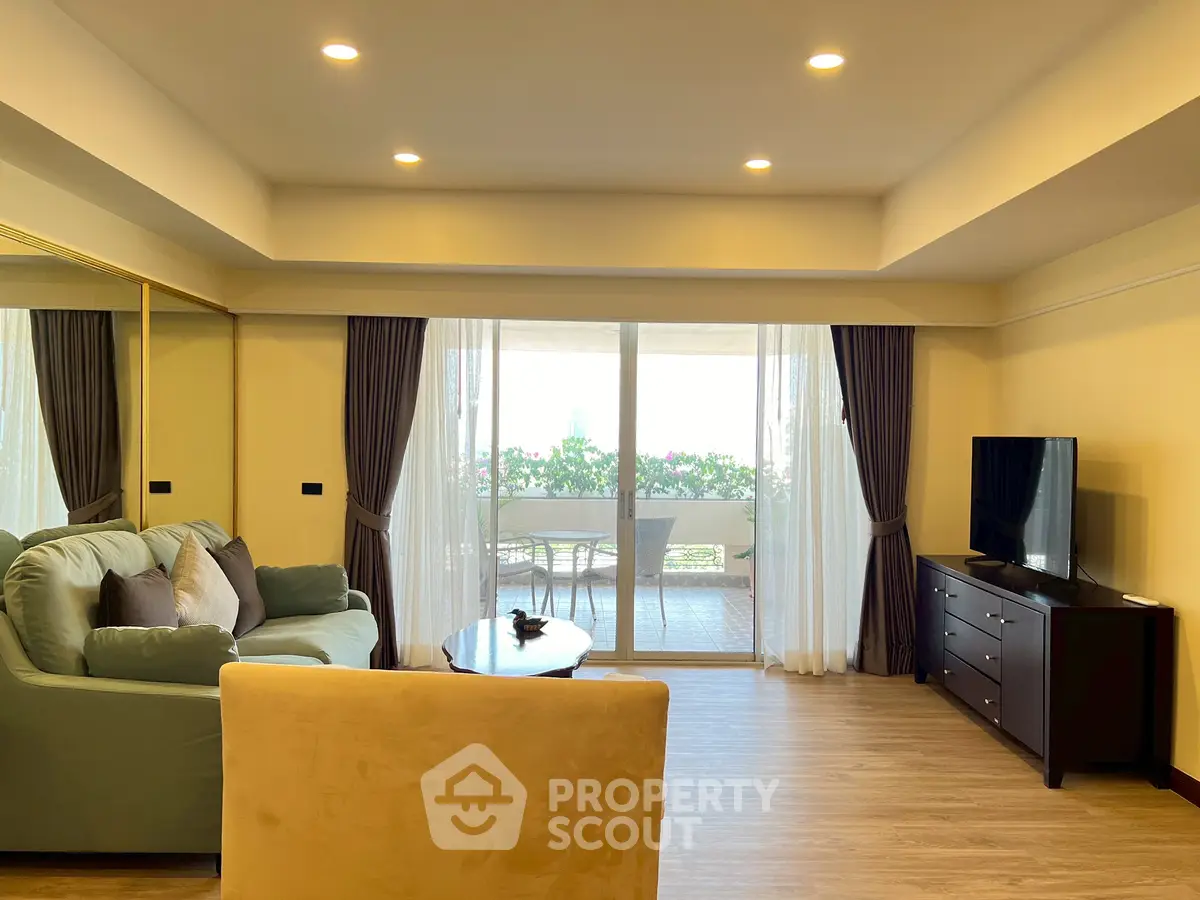 Spacious living room with cozy seating and balcony view