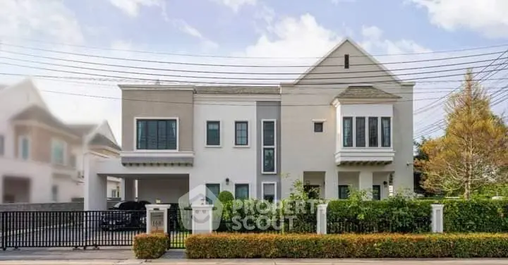 Stunning modern two-story house with lush garden and gated entrance, perfect for family living.