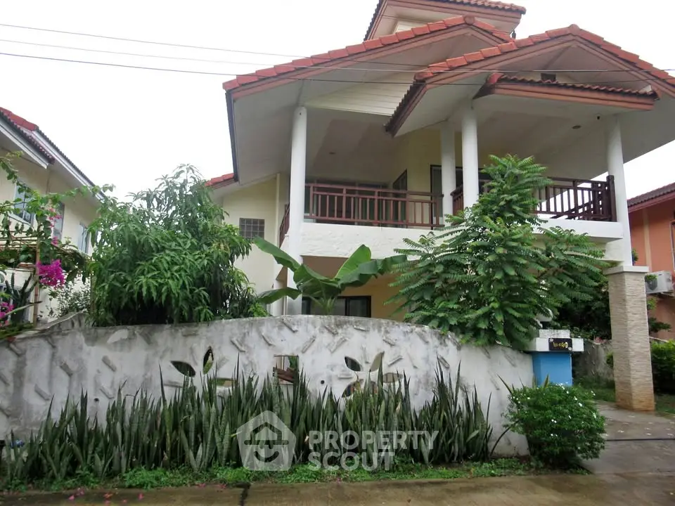 Charming two-story house with lush garden and balcony in a serene neighborhood.
