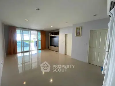 Spacious modern living room with large windows and built-in entertainment center.