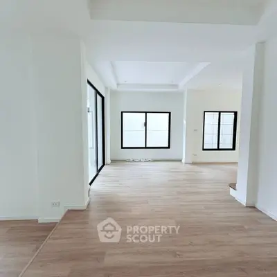 Spacious modern living room with large windows and wooden flooring