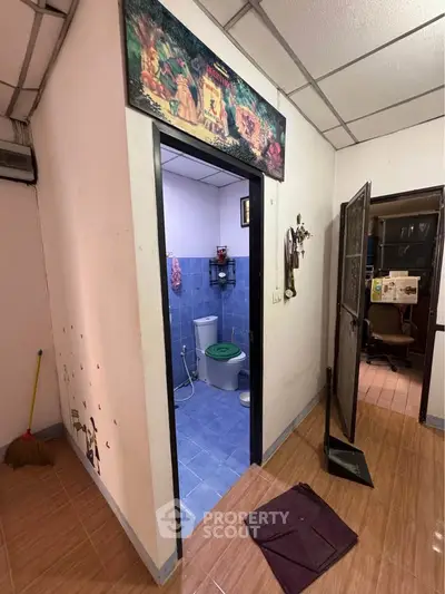 Cozy interior with tiled bathroom and adjacent room, ideal for compact living spaces.