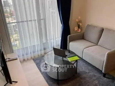 Modern living room with large window, cozy sofa, and stylish decor in a high-rise apartment.