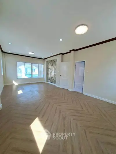 Spacious living room with large windows and elegant flooring