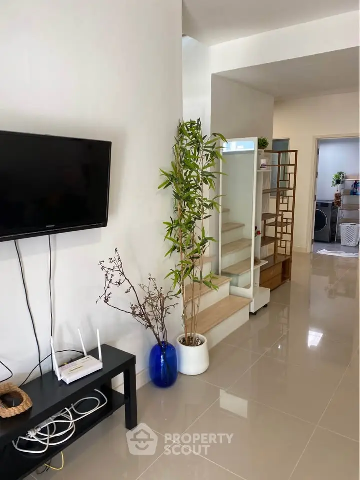 Modern living room with sleek design, TV, and stylish decor in a contemporary home.