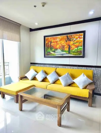 Stylish living room with vibrant yellow sofa and scenic wall art, perfect for modern urban living.
