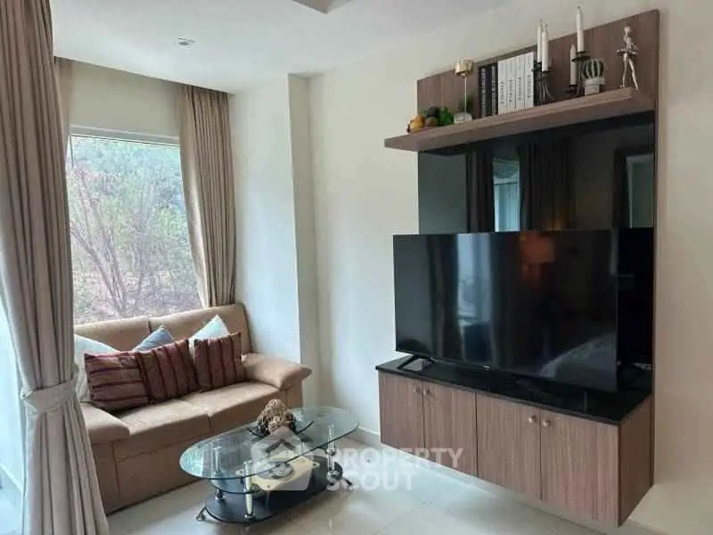 Modern living room with sleek TV unit and cozy sofa, perfect for relaxation.