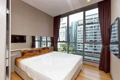 Modern bedroom with large windows offering stunning city views in a high-rise apartment.