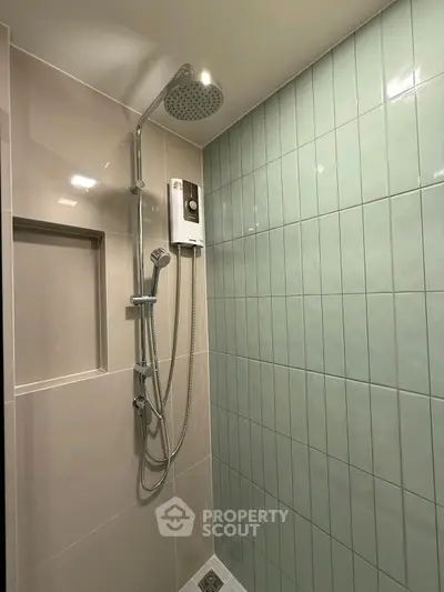 Modern bathroom shower area with sleek tiles and rainfall showerhead