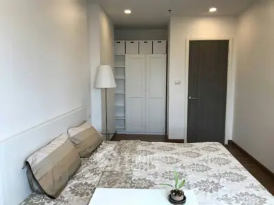 Modern bedroom with stylish decor and ample storage space in a cozy apartment.