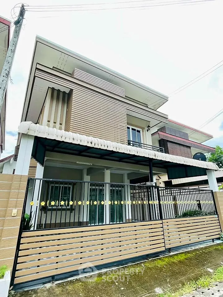 Modern two-story house with stylish facade and gated entrance in suburban neighborhood.