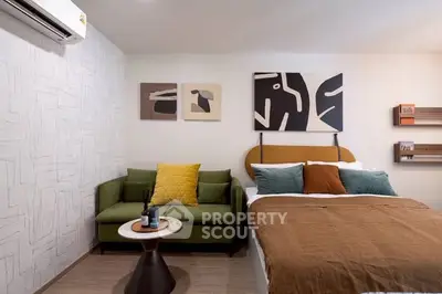 Modern bedroom with stylish decor, cozy bed, and chic green sofa.