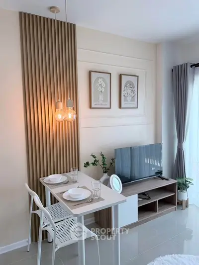 Modern living room with stylish decor, featuring a TV stand, dining area, and elegant lighting.