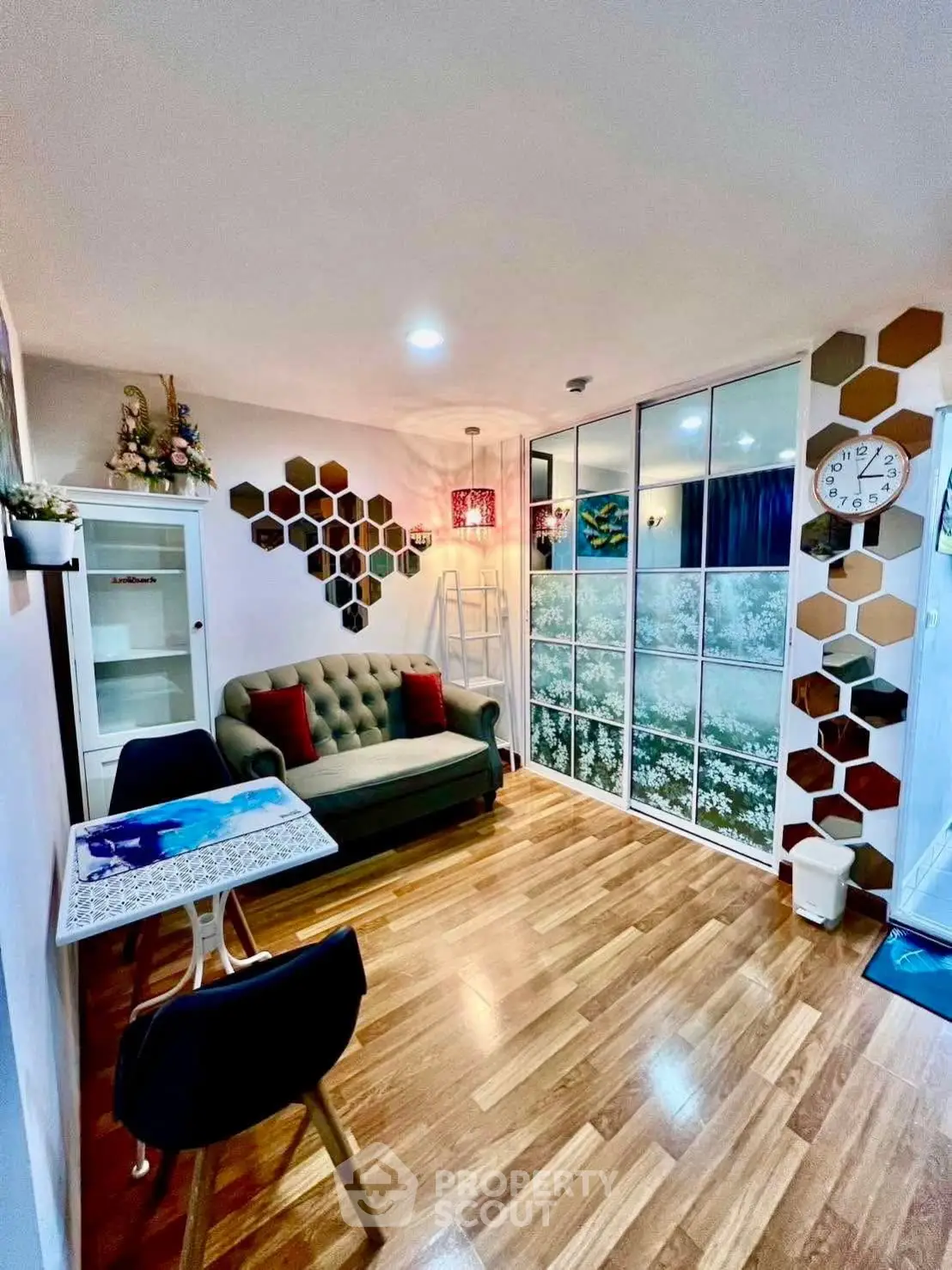 Charming living room with unique hexagonal wall decor and cozy seating area, perfect for relaxation.