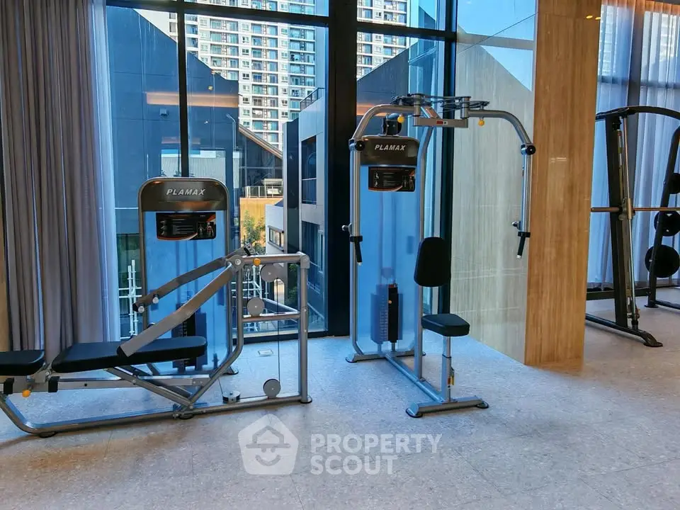 Modern gym with state-of-the-art equipment and city view, perfect for fitness enthusiasts.