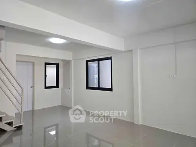 Spacious modern living room with sleek tile flooring and large windows for natural light.