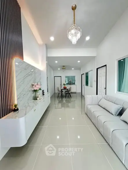 Modern living room with elegant chandelier and sleek marble accent wall