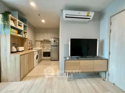 Modern open-plan living room and kitchen with sleek appliances and stylish decor.