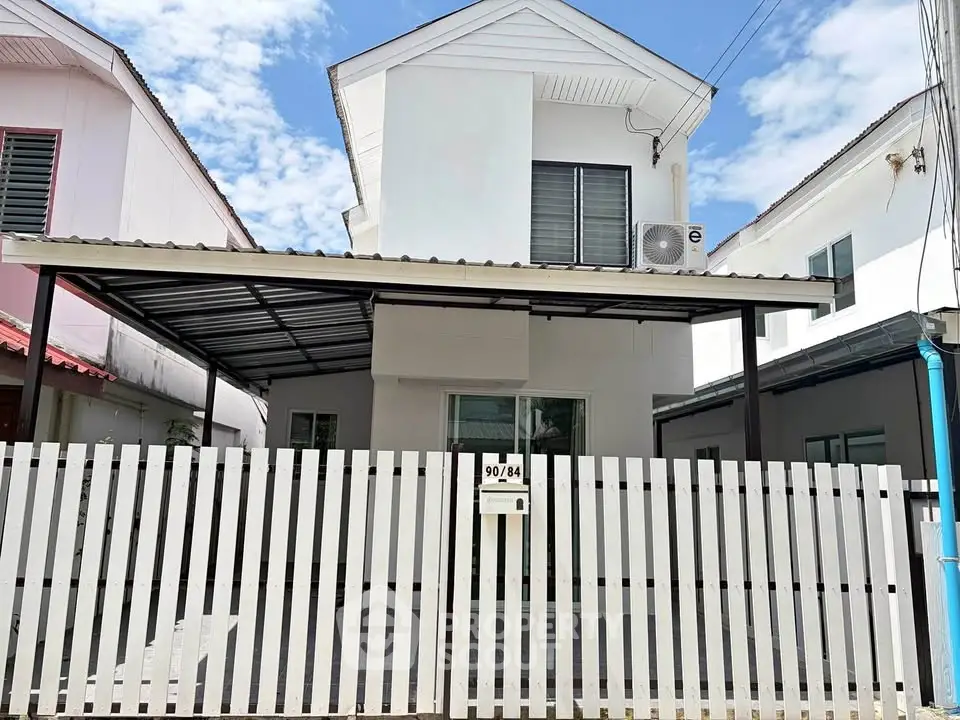 Charming two-story white house with modern design and fenced front yard, perfect for family living.