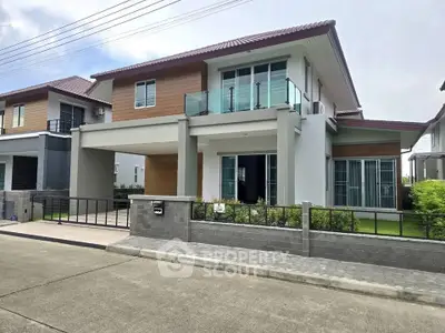 Modern two-story house with glass balcony and spacious driveway in suburban neighborhood.