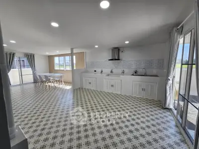 Spacious open-layout kitchen with elegant tile flooring and ample natural light.