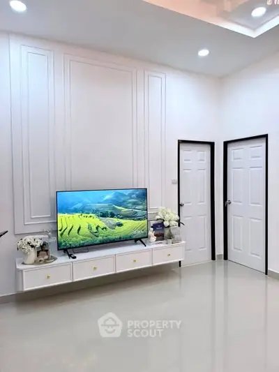 Modern living room with sleek TV unit and elegant wall paneling, showcasing minimalist design.