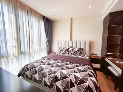 Modern bedroom with stylish geometric bedding and large windows for natural light.