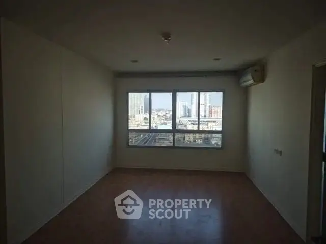Spacious empty room with large windows offering cityscape views, ideal for customization.