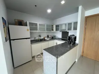 Modern kitchen with sleek cabinets and granite countertops in a stylish apartment.
